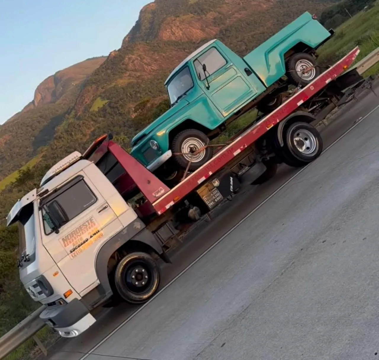 Carro antigo verde transportado pela Noroeste Guincho